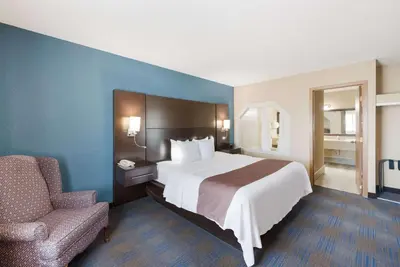 a hotel room with a bed and a chair at Quality Inn Upper Sandusky in Upper Sandusky