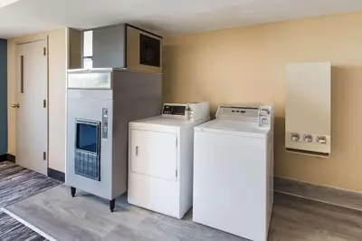 a laundry room with a washer and a refrigerator at Quality Inn Upper Sandusky in Upper Sandusky