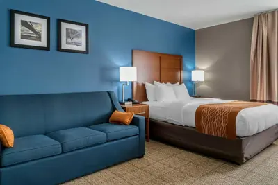 a hotel room with a bed and a couch at Comfort Inn East Oregon - Toledo in Oregon