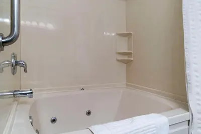 a white bath tub in a bathroom with a towel at Comfort Inn East Oregon - Toledo in Oregon
