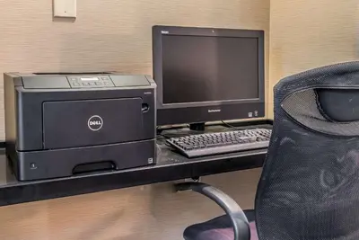 a computer sitting on a desk with a chair at Comfort Inn & Suites Piqua-Near Troy-I75 in Piqua