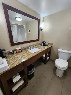 a bathroom with a sink and a toilet and a mirror at Comfort Inn & Suites Piqua-Near Troy-I75 in Piqua