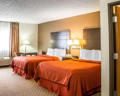 a hotel room with two beds with orange sheets at Quality Inn Elyria in Elyria