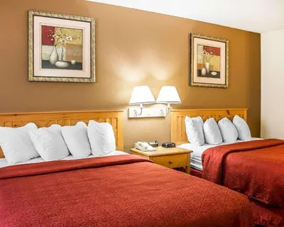 a hotel room with two beds with red sheets at Quality Inn Elyria in Elyria