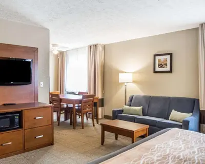 a hotel room with a couch and a dining room at Comfort Inn Bellefontaine in Bellefontaine