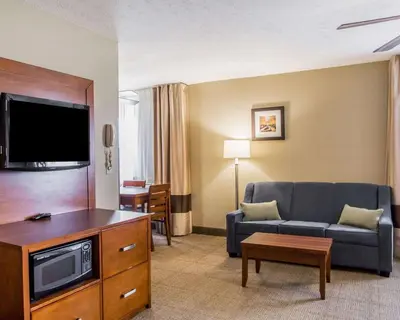 a living room with a couch and a flat screen tv at Comfort Inn Bellefontaine in Bellefontaine