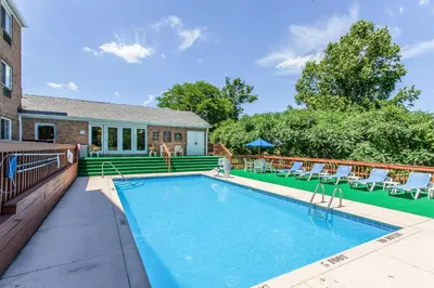 a swimming pool with chairs and a house at Comfort Inn Independence - Cleveland in Independence