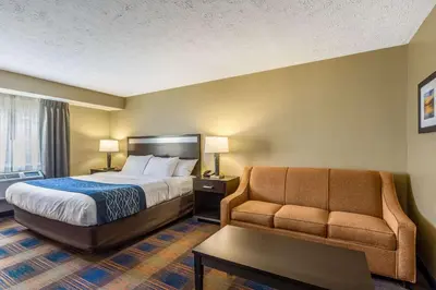 a hotel room with a bed and a couch at Comfort Inn Independence - Cleveland in Independence