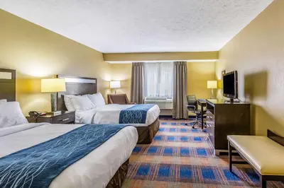 a hotel room with two beds and a desk at Comfort Inn Independence - Cleveland in Independence