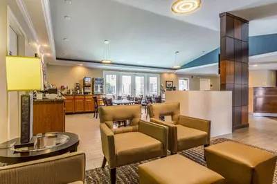 a lobby with chairs and a table and a kitchen at Comfort Inn Independence - Cleveland in Independence