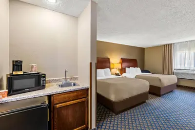 a hotel room with two beds and a tv at Quality Inn & Suites Seville in Seville