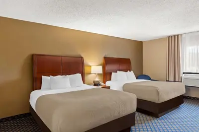 a hotel room with two beds and a window at Quality Inn & Suites Seville in Seville