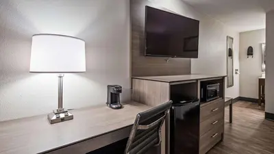 a room with a desk with a television and a lamp at SureStay Hotel by Best Western Findlay in Findlay