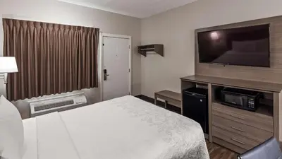 a hotel room with a bed and a flat screen tv at SureStay Hotel by Best Western Findlay in Findlay