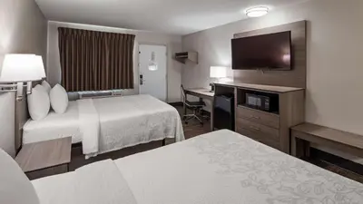 a hotel room with two beds and a flat screen tv at SureStay Hotel by Best Western Findlay in Findlay