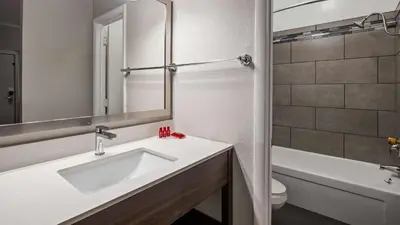 a bathroom with a sink and a toilet and a mirror at SureStay Hotel by Best Western Findlay in Findlay