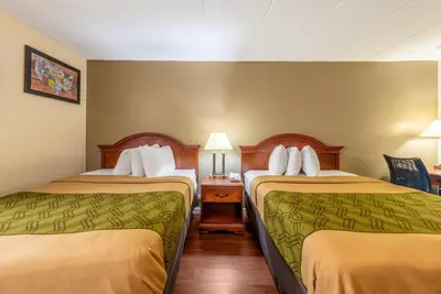 a hotel room with two beds and a table at Econo Lodge Franklin - Springboro in Franklin
