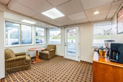 a waiting room with chairs and a table and windows at Econo Lodge Franklin - Springboro in Franklin