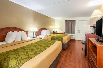 a hotel room with two beds and a flat screen tv at Econo Lodge Franklin - Springboro in Franklin