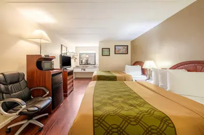 a hotel room with two beds and a chair at Econo Lodge Franklin - Springboro in Franklin