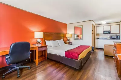a hotel room with a bed and a desk and a chair at Econo Lodge in Norwalk