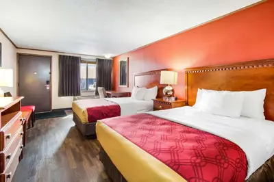 a hotel room with two beds and a desk at Econo Lodge in Norwalk