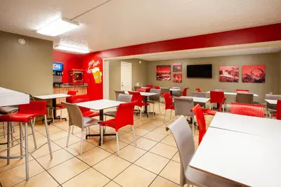 a restaurant with red walls and tables and chairs at Super 8 by Wyndham Sandusky in Sandusky