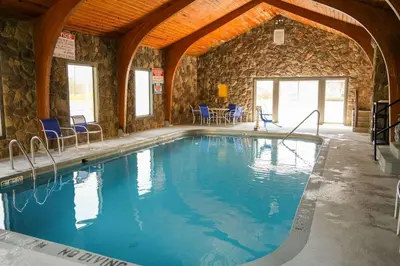a large swimming pool with blue chairs in a building at Econo Lodge Wooster in Wooster
