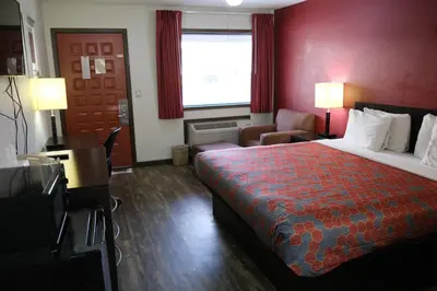 a hotel room with a bed and a red wall at Econo Lodge Wooster in Wooster