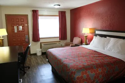a hotel room with a bed and a red wall at Econo Lodge Wooster in Wooster