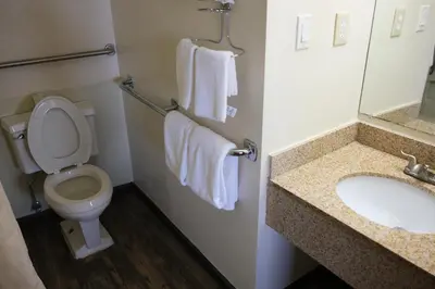 a bathroom with a toilet and a sink and towels at Econo Lodge Wooster in Wooster