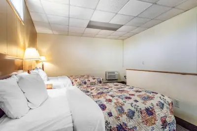 a hotel room with two beds and a tv at Rodeway Inn Sandusky North in Sandusky