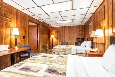 a hotel room with two beds and a desk at Rodeway Inn Sandusky North in Sandusky