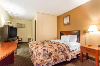 a hotel room with a bed and a flat screen tv at Rodeway Inn Sandusky North in Sandusky