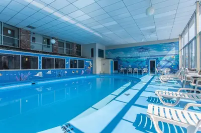 a large swimming pool with white chairs and a swimming pool at Rodeway Inn Sandusky North in Sandusky