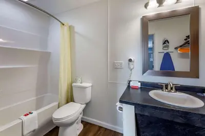 a bathroom with a toilet and a sink and a mirror at Econo Lodge Inn & Suites Sandusky South in Sandusky