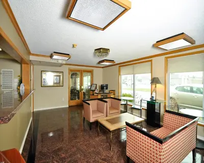 a living room with chairs and a table at Baymont by Wyndham Sandusky in Sandusky