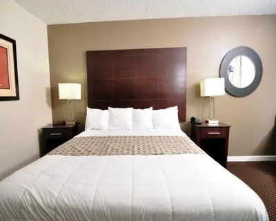 a large bed in a hotel room with two lamps at Baymont by Wyndham Sandusky in Sandusky