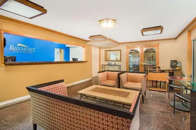 a living room with a couch and a table at Baymont by Wyndham Sandusky in Sandusky