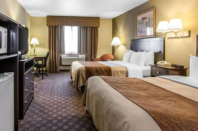 a hotel room with two beds and a television at Quality Inn Defiance in Defiance