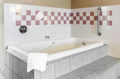 a white bath tub in a tiled bathroom at Quality Inn Defiance in Defiance