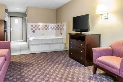 a hotel room with a tub and a tv and chairs at Quality Inn Defiance in Defiance