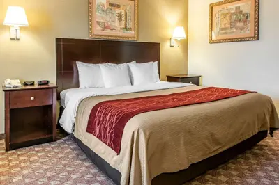 a hotel room with a large bed with a red blanket at Quality Inn Defiance in Defiance