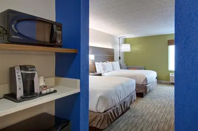 a hotel room with two beds and a tv on a wall at Holiday Inn Express Columbus South - Obetz by IHG in Obetz