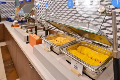 a buffet line with trays of food on display at Holiday Inn Express Columbus South - Obetz by IHG in Obetz