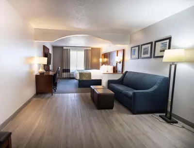 a hotel room with a bed and a couch at Comfort Suites Springfield I-70 in Springfield