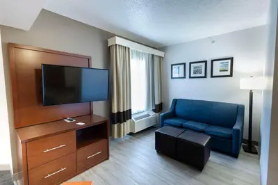 a living room with a blue couch and a flat screen tv at Comfort Suites Springfield I-70 in Springfield