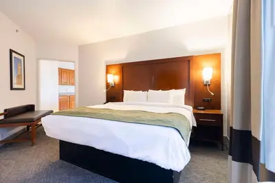 a hotel room with a large bed and a desk at Comfort Suites Springfield I-70 in Springfield