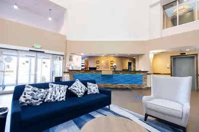 a living room with a blue couch and a chair at Comfort Suites Springfield I-70 in Springfield