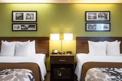a hotel room with two beds and two lamps at Sleep Inn & Suites Oregon - Toledo in Oregon